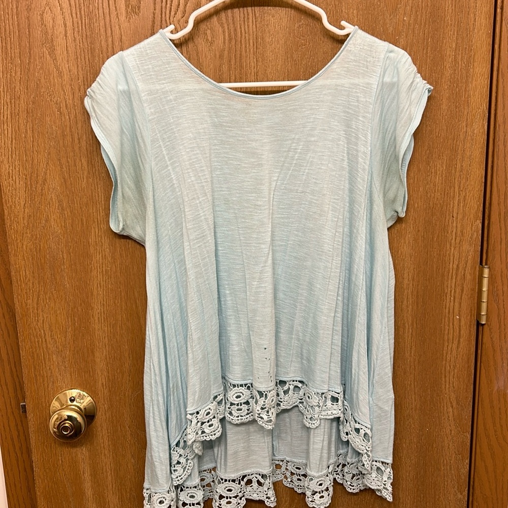 Short sleeve shirt with longer hanging in the back w/cute detail on the bottom